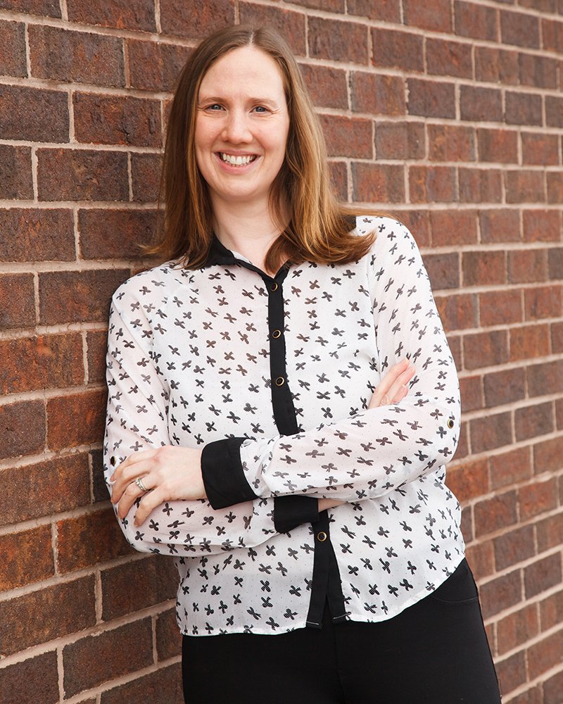 Mallory leaning against a brick wall